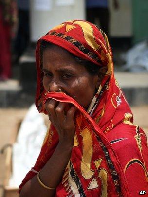 A woman covers her nose at a make-shift morgue in Savar, near Dhaka