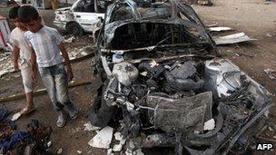 Iraqi boys inspect site of car bomb attack in Baghdad on 16 April