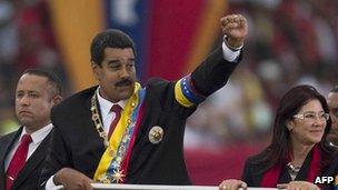 Venezuelan President Nicolas Maduro (centre) raises his clenched fist after taking office in April