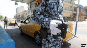 Iraqi policeman holds an explosion detection device at a checkpoint in Baghdad (19 April 2013)