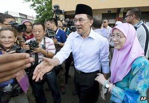Anwar Ibrahim, centre, greets supporters with his wife Wan Azizah after voting at Penanti in Penang state in northern Malaysia, 5 May