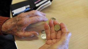 An elderly person with coins