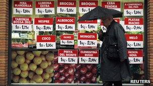 Man walking past grocery shop in Spain