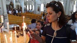 Syrian Christians light candles before a mass marking the Palm Sunday on April 28 in Damascus