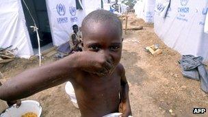 Child eating at a refuge camp in DR Congo