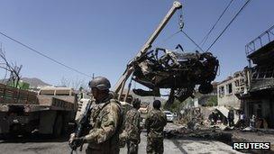 A Nato soldier stands at the site of a suicide attack in Kabul (16 May 2013)
