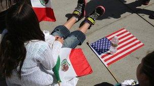 Girl scouts with Mexican and American flags rest after walking in a Cinco de Mayo parade on 4 May 2013 in Denver, Colorado.