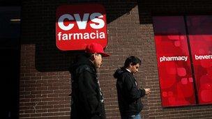 Hispanic residents walk by a bilingual sign for a CVS pharmacy on 28 March 2011 in Union City, New Jersey