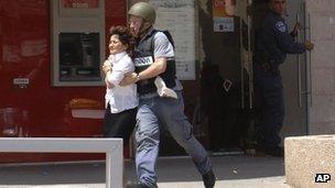 A woman being taken out of a bank in Beersheba, Israel, after a shooting, 20 May 2013