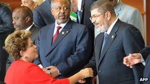 Brazilian President Dilma Rousseff (L) greets Egyptian counterpart Mohammed Morsi (R) at the AU summit