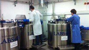 Scientists working near big freezers containing blood samples