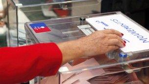 hand putting vote into ballot box