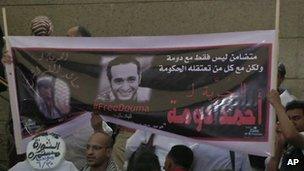 Supporters wave a banner for activist Ahmed Douma