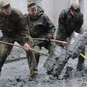 German soldiers shovel mud off a street in Passau. Photo: 4 June 2013