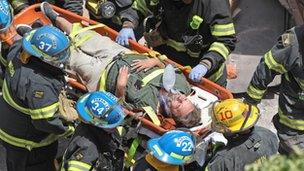 Firefighters carry a survivor from the rubble of a building collapse in downtown Philadelphia 5 June 2013