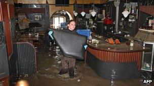 Helpers clean a flooded bar in the city of Passau in Germany