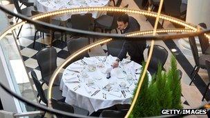 A waiter laying a table in a restaurant in France
