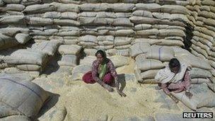 Women labourers collect wheat at a warehouse in Punjab