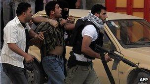 Palestinians from the Fatah-linked Al-Aqsa Martyrs' Brigades arrest an alleged Hamas member in the West Bank city of Nablus, 14 June 2007