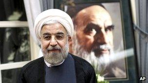 President elect Hassan Rouhani, stands in front of a portrait of the late Iranian Ayatollah Khomeini, during a visit to his shrine