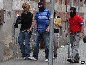 Masked Czech police officers escort the prime minister's chief of staff, Jana Nagyova, to a police station in Ostrava, 14 June
