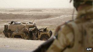 Soldiers inspect a Snatch Land Rover in Iraq