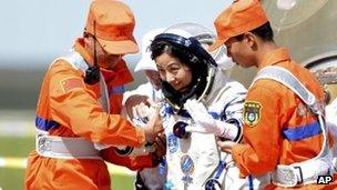 Chinese astronaut Wang Yaping, centre, goes out of the re-entry capsule of China's Shenzhou 10 spacecraft after its successful landing in Siziwang Banner, north China's Inner Mongolia Autonomous Region on 26 June 2013