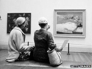Visitors evaluate a painting at an exhibition of modern art, organised by the Contemporary Art Society on the theme of religion, in London's Tate Gallery