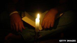 Man reads the Bible by candlelight in Syria monastery