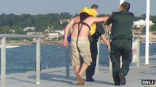 Injured yachtsman being helped to ambulance