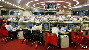 Floor traders study stock prices in the Hong Kong Stock Exchange