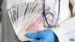 Doctor holding banknotes