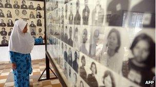 A female Cambodian-Muslim looks at portrait photos of victims of the Khmer Rouge regime displayed for tourists at the Tuol Sleng Genocide Museum in Phnom Penh on 4 June 2013