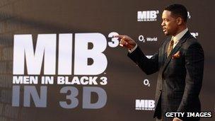 Actor Will Smith in front of a Men in Black 3 poster