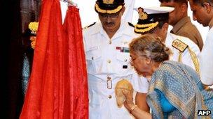 Gursharan Kaur, the wife of Indian Prime Minister Manmohan Singh, breaks a coconut on the hull of India's first nuclear-powered submarine INS Arihant in 2009