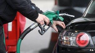 Person filling car at petrol pump