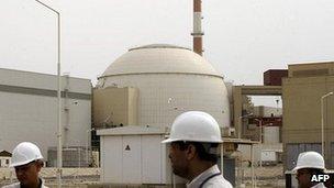 Iranian technicians walk outside the building housing the reactor of Bushehr nuclear power plant
