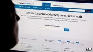A woman looks at the HealthCare.gov insurance exchange internet site showing a "Please wait" page, in this 1 October 2013 file photo in Washington, DC