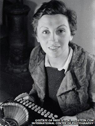 Gerda Taro sitting at a typewriter