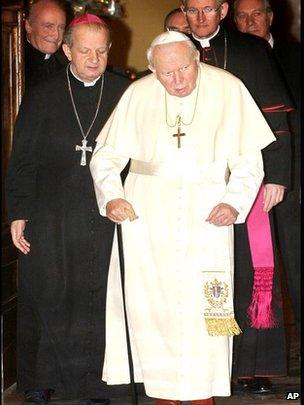 Pope John Paul II is aided by his personal secretary Archbishop Stanislaw Dziwisz, left, as he arrives at the Clementine hall at the Vatican for an audience on 14 December 2001.
