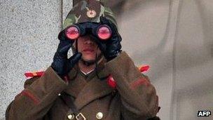 A North Korean soldier looks on at the South side at the truce village of Panmunjom in the Demilitarised Zone dividing the two Koreas on 12 March 2014