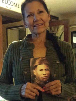 Nuchi Nashoba holding a photo of her great grandfather Ben Carterby
