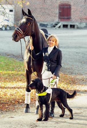 Verity Smith holding her horse and her guide dog Uffa
