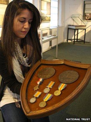 A volunteer shows Arthur and Robert Greg's medals