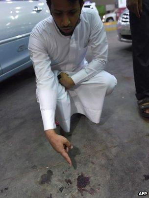 A Saudi official points at a stain of blood on the ground at the scene of Tuesday's shooting in Riyadh. Photo: 14 October 2014