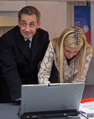 Nicolas Sarkozy votes next to an unnamed woman at a laptop in Paris, 29 November