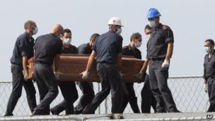 Rescuers carrying coffin of a Lampedusa migrant, 12 Oct 13
