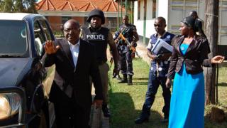 Charles Mumbere, king of Rwenzururu waves outside court.