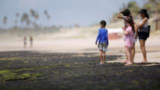 People look at oil spilled on a beach in Bahia state, Brazil. Photo: 12 October 2019