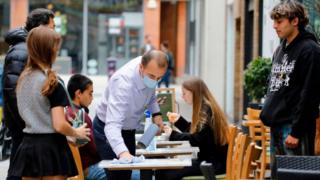 A waiter cleaning a table